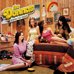 Album cover for the album Spend the Night by The Donnas. It shows the band in pajamas sitting on a bed in a messy bedroom.