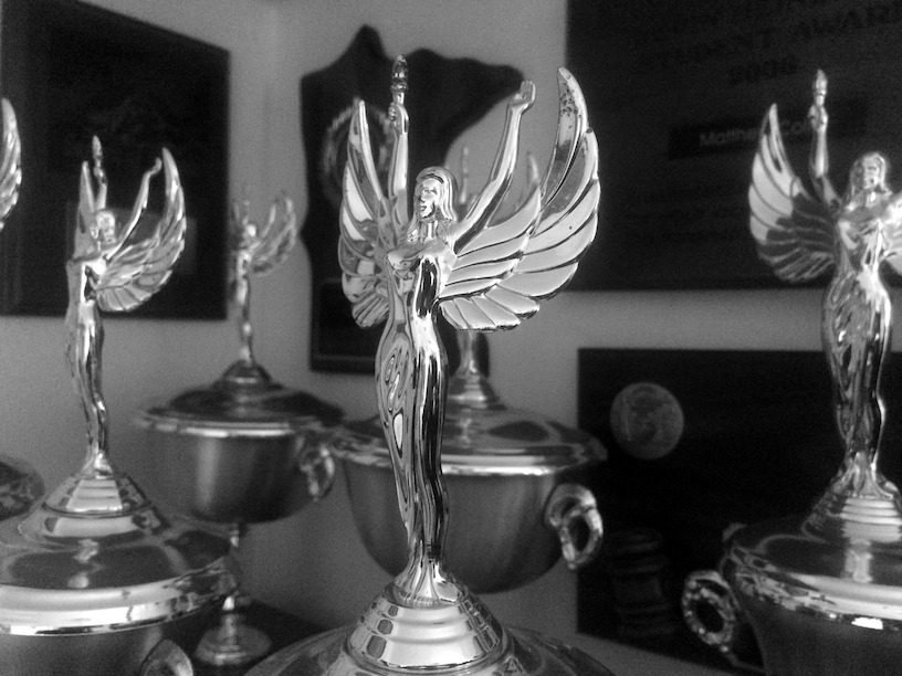 Photo of a collection of trophies in black and white.